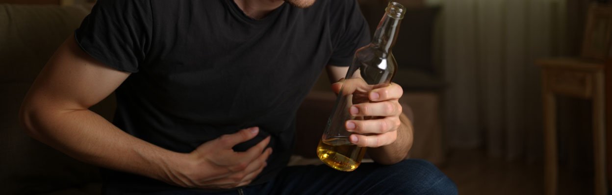 Мужчина держится рукой за живот